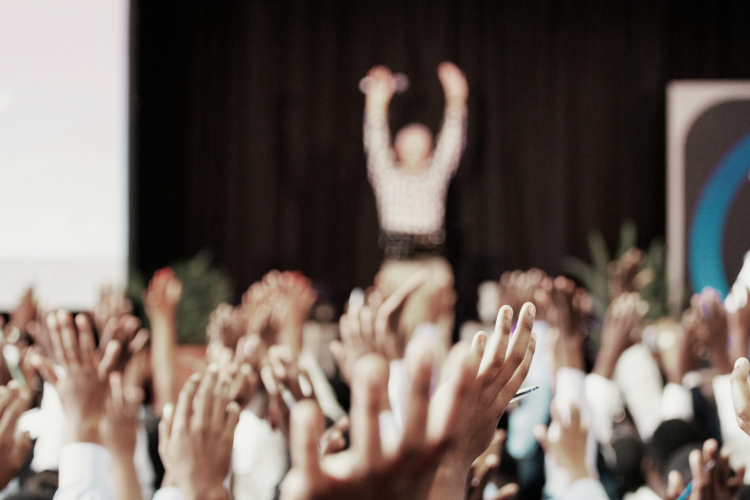 manos levantadas en un evento profesional, imagen conceptual de trabajo en equipo, liderazgo y toma de decisiones